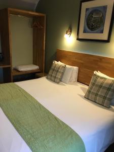 a bedroom with a large white bed with two pillows at The Valley Hotel, Anglesey in Valley