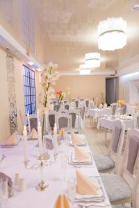 ヴィーンヌィツャにあるHotel Dobrodiyの白いテーブルと白い椅子が備わる宴会場