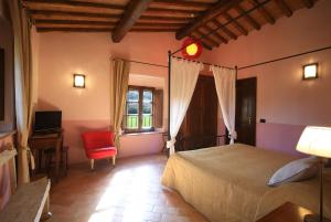 a bedroom with a large bed and a red chair at Molino Di Foci in San Gimignano