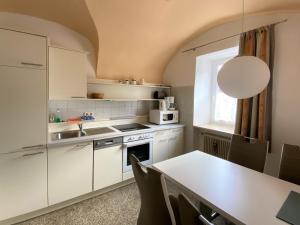 a kitchen with white cabinets and a table and a window at Haus Pleterski in Obervellach
