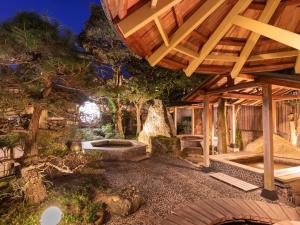 un patio esterno con pergolato in legno di Tamai Bekkan a Matsue