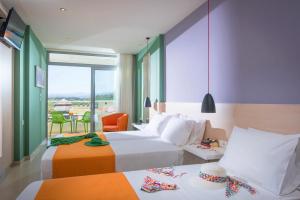 een hotelkamer met 2 bedden en een balkon bij Corissia Princess Hotel  in Georgioupolis