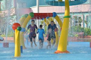 eine Gruppe von Menschen, die in einem Wasserpark spielen in der Unterkunft Bella Vista Waterfront Resort, Kuah Langkawi in Kuah