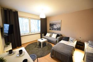 een woonkamer met een bank en een woonkamer met bij Rental Apartment Kupittaa Suomen Vuokramajoitus Oy in Turku