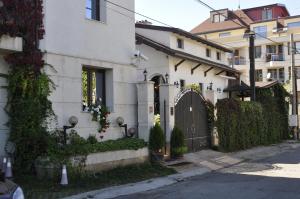 ein weißes Haus mit einem Tor in einer Straße in der Unterkunft Hotel Romantic in Sofia