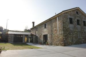 an old stone building with a garage at Lugar das Marías in Jove