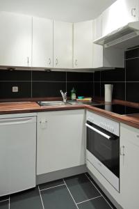 uma cozinha com armários brancos e um lavatório em Hotel Zum Goldenen Stern em Prüm