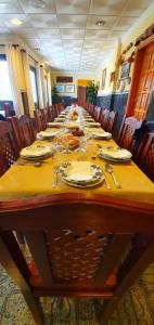a long table with plates and silverware on it at Hotel Sonia Chipude in El Cercado