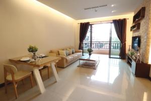 a living room with a table and a couch at Pattaya City Resort by Harmony in Pattaya