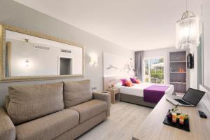 a living room with a couch and a bed at Garden Holiday Village - Adults Only in Playa de Muro