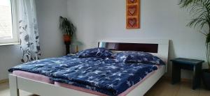 Bett mit blauer Bettdecke und 2 Kissen in der Unterkunft Feriendomizil Roger Wohnung 2 in Leipzig