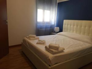 sypialnia z białym łóżkiem i 2 ręcznikami w obiekcie Italianflat - Rentroom Verona w Weronie