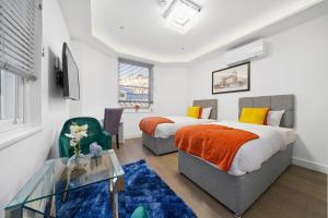 伦敦City Prime Apartments的一间卧室配有两张床和一张玻璃桌