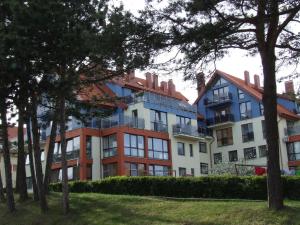 a large building with trees in front of it at Nidos Laivas in Nida