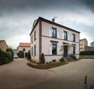 a white house with a black roof at L'Enclos de Ribains in Aubière