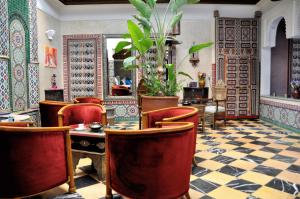 un ristorante con tavolo e sedie in camera di Riad l'Escale de Marrakech a Marrakech