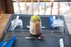 uma mesa com uma pequena planta num frasco sobre uma mesa em Domus Porto Di Traiano Resort em Fiumicino