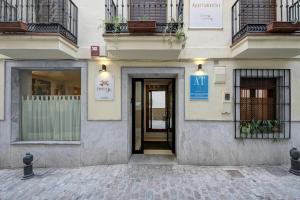 un edificio con una puerta con un cartel. en Apartamentos Turísticos Centro, en Granada