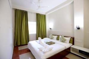 a hotel room with two beds with green curtains at The Q Villa, Udaipur in Udaipur