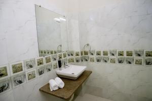 a white bathroom with a sink and a mirror at The Q Villa, Udaipur in Udaipur