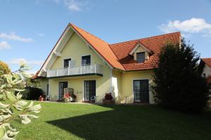 ein gelbes Haus mit einem orangenen Dach und einem Hof in der Unterkunft Sonntagsberg Hof Familie Fiedler in Bad Waltersdorf