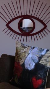 a mirror on the wall above a couch with a pillow at L'attrape coeurs in Mantilly