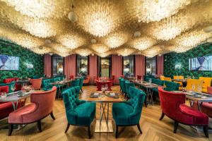 a restaurant with green walls and tables and chairs at Boutique Hotel Albora in Saint Petersburg