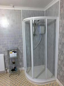 una doccia con una porta in vetro in un bagno di Dunrigh Guest House a Oban