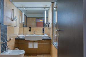 a bathroom with a sink and a mirror at Best Western Hotel Bremen City in Bremen