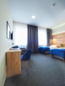 una camera d'albergo con 2 letti e una scrivania di S7 Hotel a Kielce