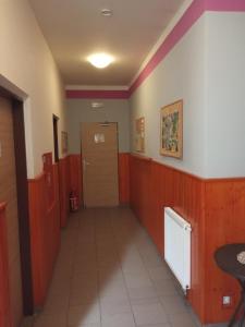 un pasillo con una puerta en una habitación con rayas rojas en Penzion & ubytování, en Chrást