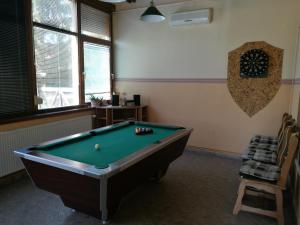 a room with a pool table and a chair at Gergely Vendégház in Zirc