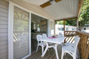 a white table and chairs on a porch at Camping La Belle Etoile in Melun