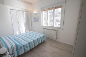 a bedroom with a bed and two windows at appartamento super ristrutturato in Celle Ligure