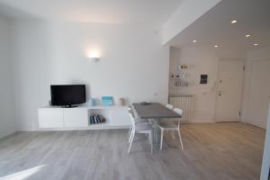 a dining room with a table and chairs and a television at appartamento super ristrutturato in Celle Ligure