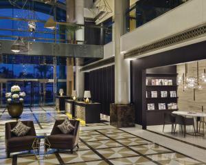 a lobby with chairs and tables in a building at Hyatt Regency Al Kout Mall in Kuwait +57 photos