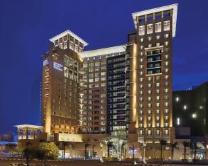 a tall building with lights on in a city at Hyatt Regency Al Kout Mall in Kuwait