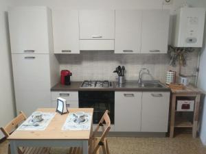 a kitchen with white cabinets and a table with chairs at Ca' d'Alfonso in Baveno