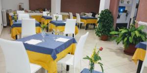 un ristorante con tavoli blu e gialli e sedie bianche di Hotel 660 a Bisignano