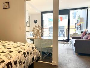 a bedroom with a bed and a table and a kitchen at ReadySet Apartments on Little Collins in Melbourne