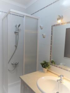 a bathroom with a shower and a sink and a mirror at CASA DA BARRA AZUL by Stay in Alentejo in Vila Nova de Milfontes