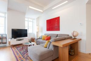 a living room with a couch and a tv at FLH Chiado Amazing Flat in Lisbon