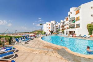 a pool at a resort with lounge chairs and buildings at E256 Citadini 39 by Mallorca Villa Selection in Alcudia