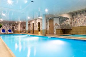 a swimming pool in a hotel with blue water at Manor Hotel in Olsztyn