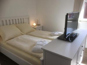 a room with a bed and a desk with a television at Inselresidenz Strandburg Apartment 209 in Juist