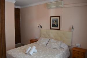 a bedroom with a bed with two white towels on it at Hotel Doña Carmen in Ronda