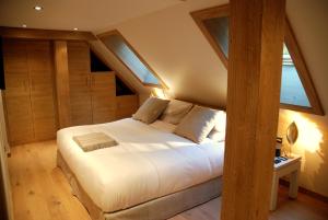 a bedroom with a large white bed in a attic at Le Grand Chalet et Spa in Niedermorschwihr