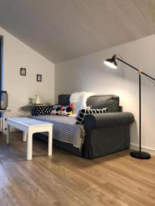 a living room with a couch and a table and a lamp at Ferienwohnung Zum Fiaker in Garmisch-Partenkirchen