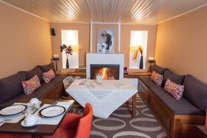 a living room with a table and a fireplace at Archontiko Argyro in Makrinítsa