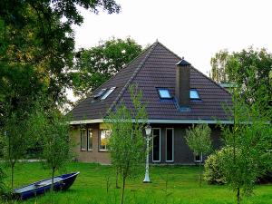 una casa con un barco delante de ella en Boerderij Zonneveld, en Rossum